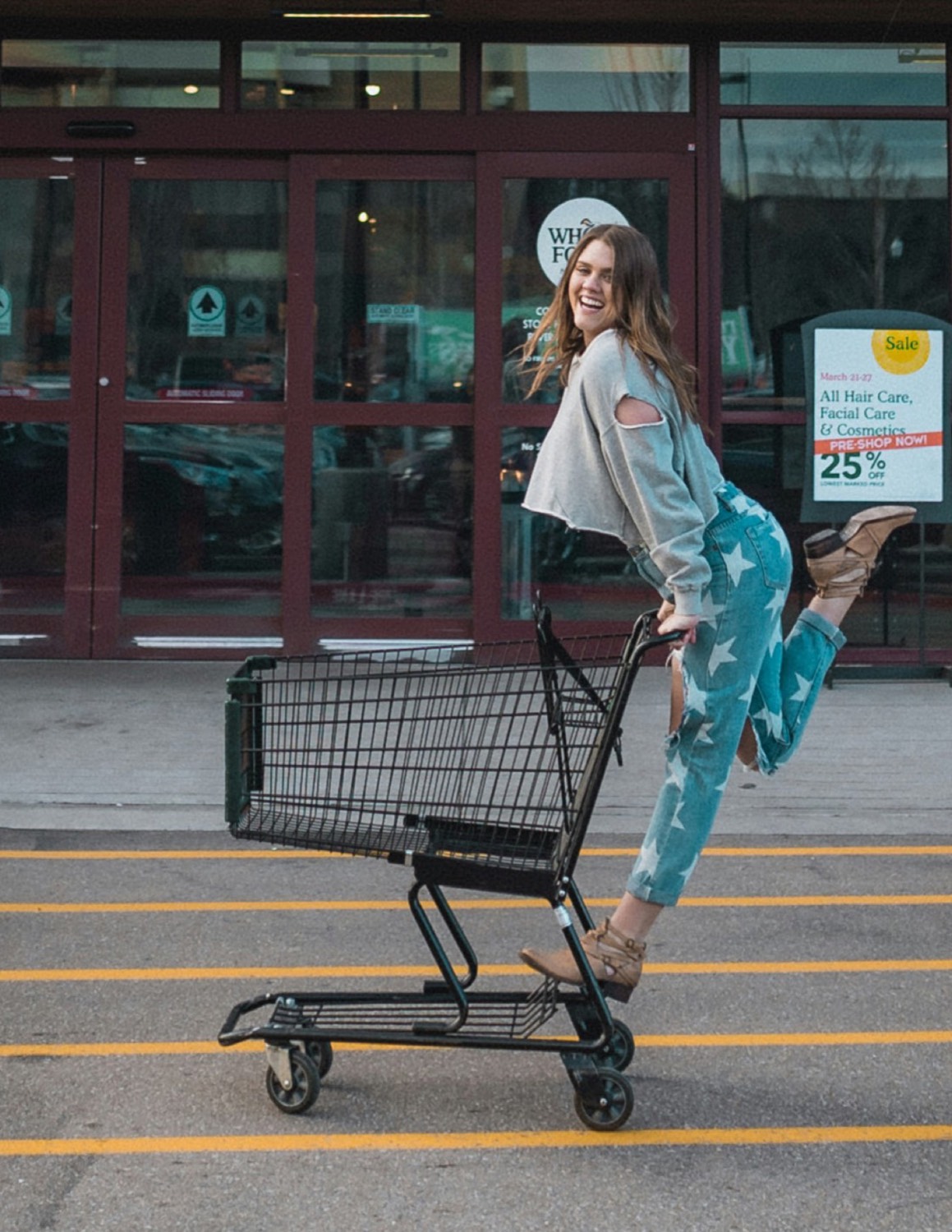 A shopper standing with a cart outside a store
