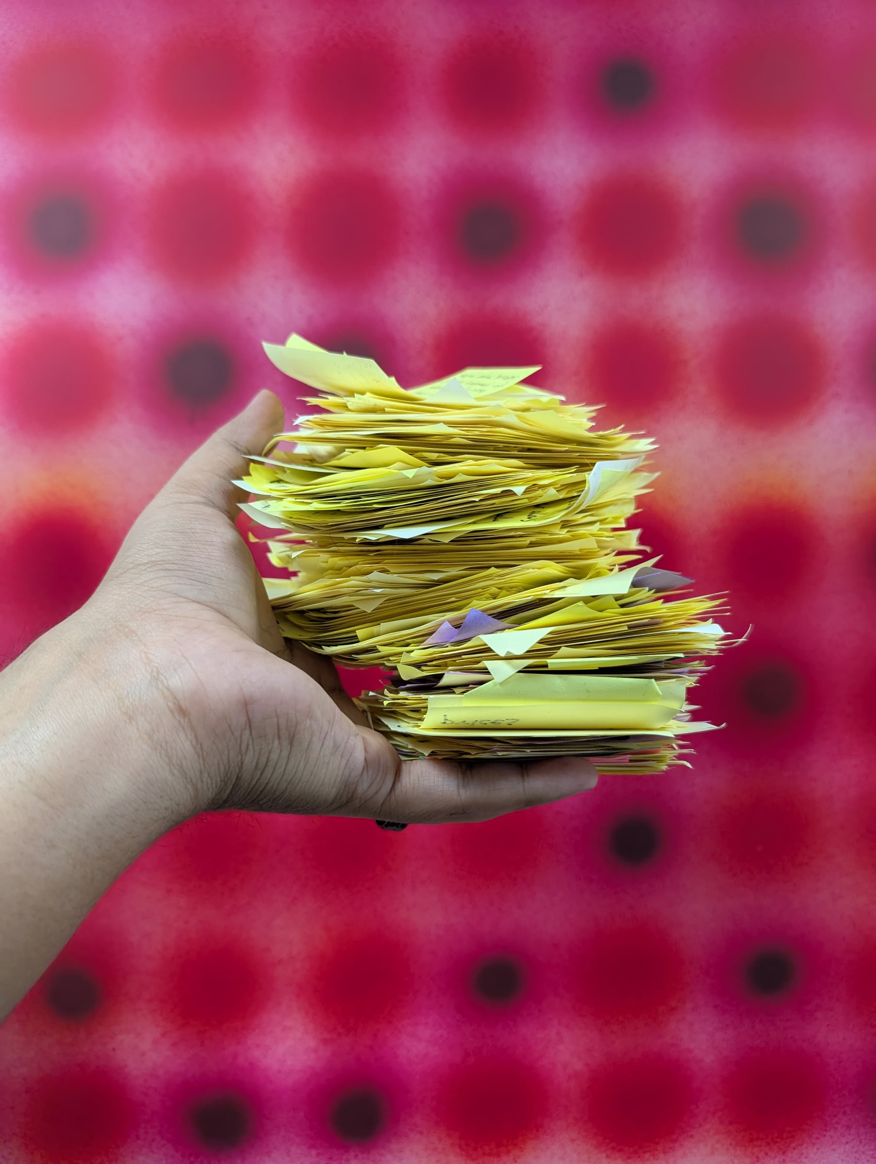 A hand holding a large stack of physical observation notes