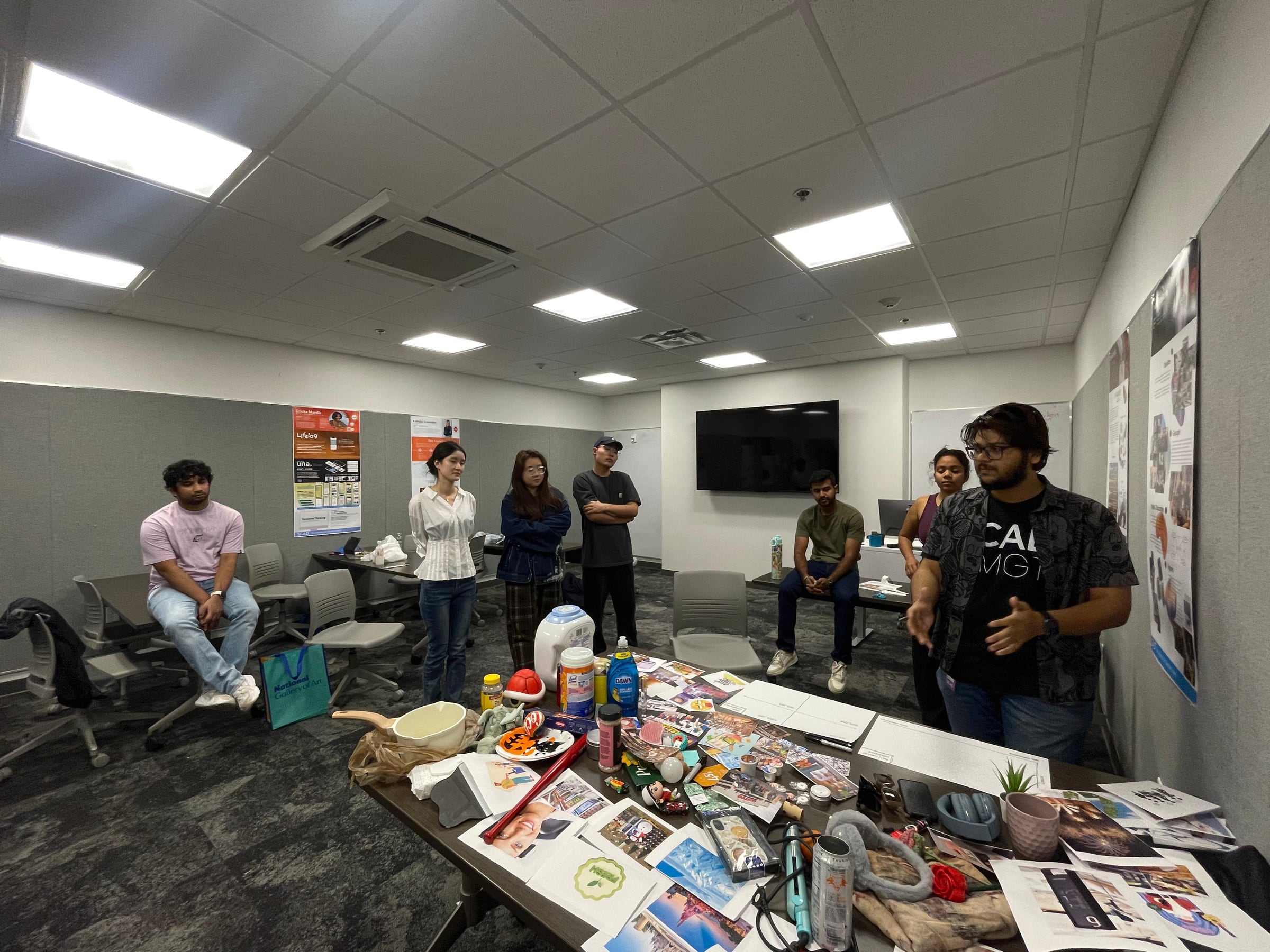 A group discussing the sensory-cue materials around a workshop table